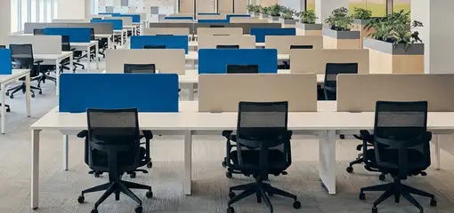Modern open-plan office space featuring clean workstations, ergonomic chairs, and sanitized carpets provided by professional office cleaning services in Hialeah, FL.