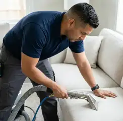 Professional upholstery cleaning technician using an extraction wand to deep-clean a fabric sofa, Hialeah, FL.